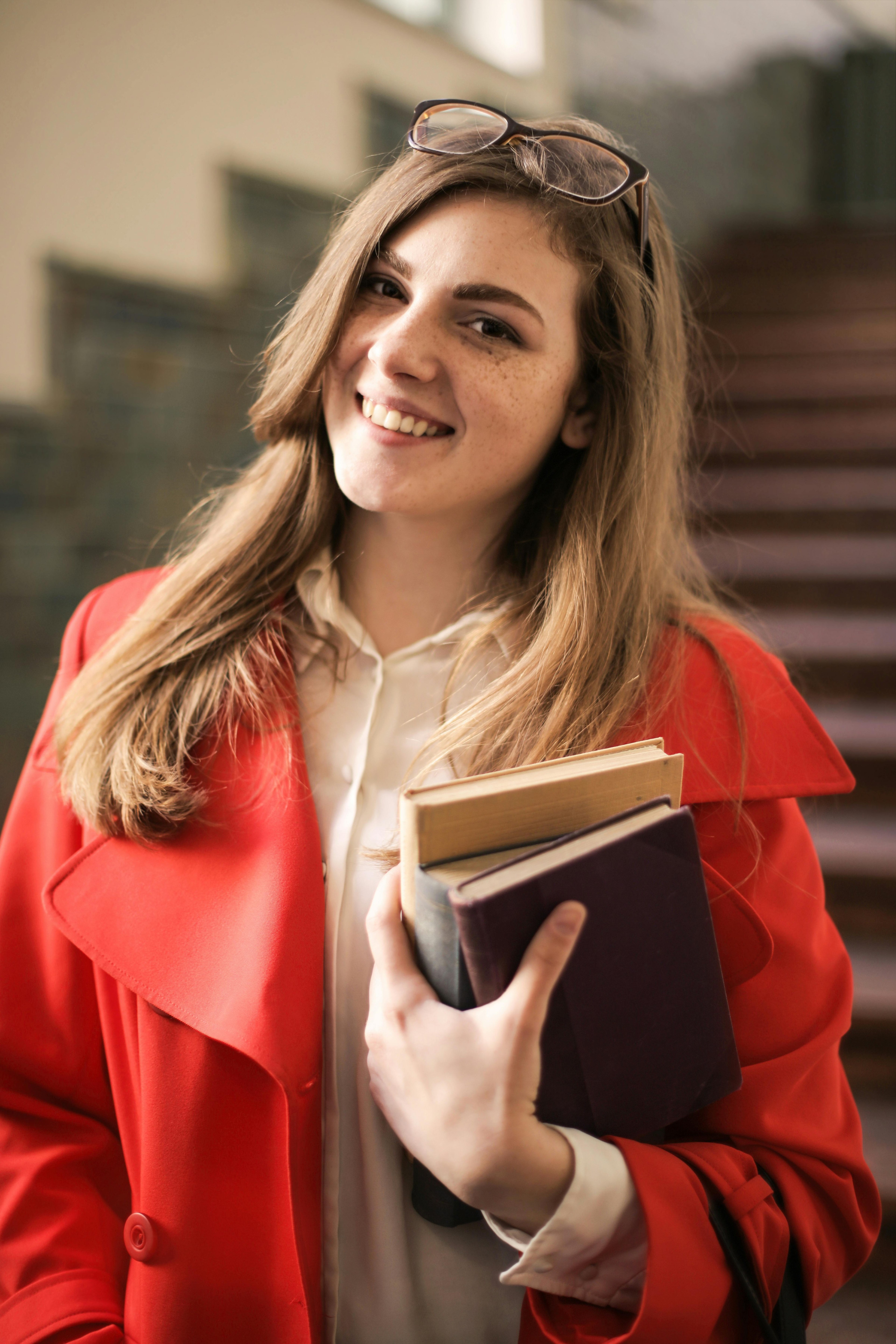 Smiling college student holding books on campus