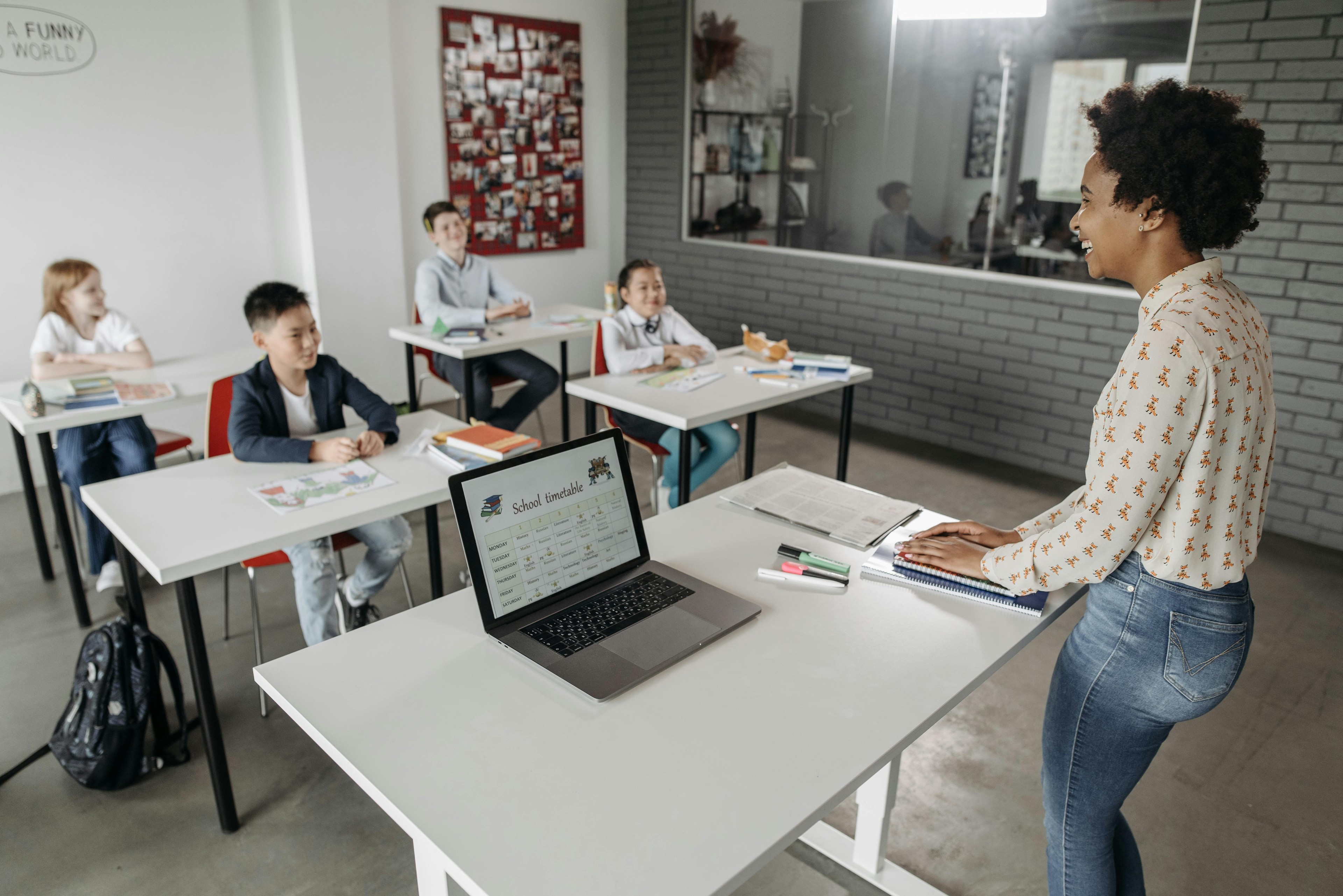 Teacher using laptop and tools in a modern classroom